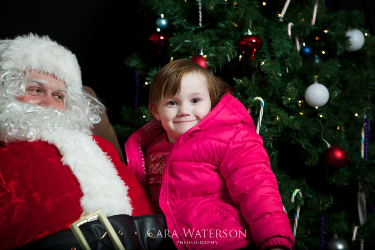 girl in pink coat on santas lap