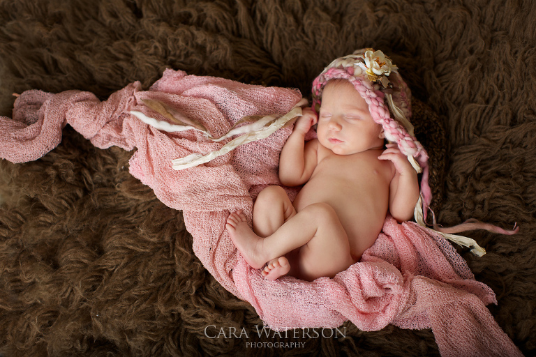 newborn in pink hat