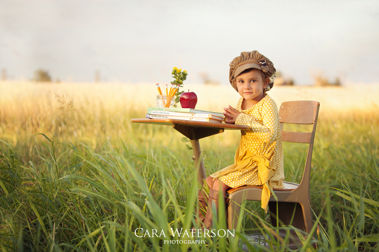 girl in brown hat at school desk