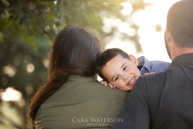 boys face over parents shoulders